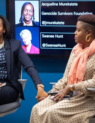 Panelist speaks holding another panelist's hand at How Women Saved Rwanda event